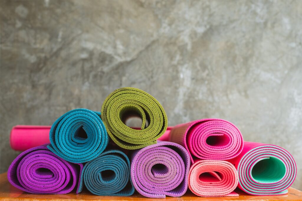 some colourful rolled yoga mats, good home workout equipment for women