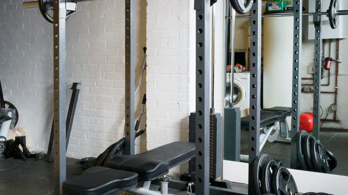 a power rack (or squat rack), with an adjustable bench and olympic barbell - staples of a home gym equipment list