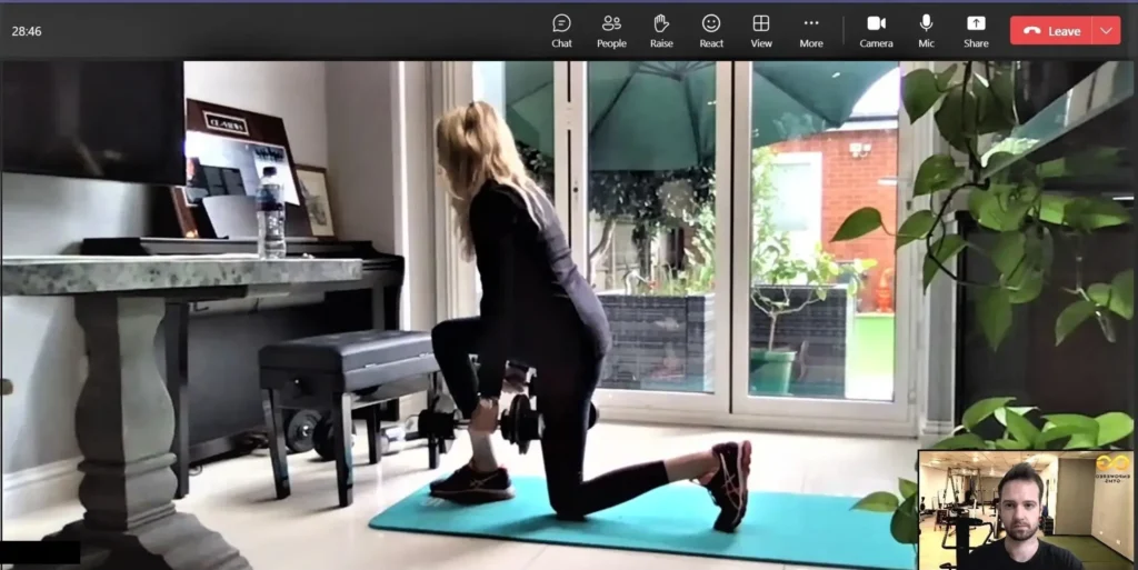lunges being performed in a home workout by a female client with her personal trainer