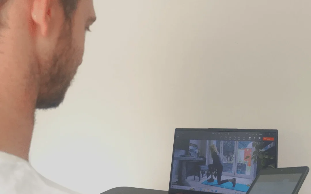 a virtual personal trainer with a client in a session via video call on a laptop. In the online personal trainer vs in person debate, video calling can be a suitable compromise
