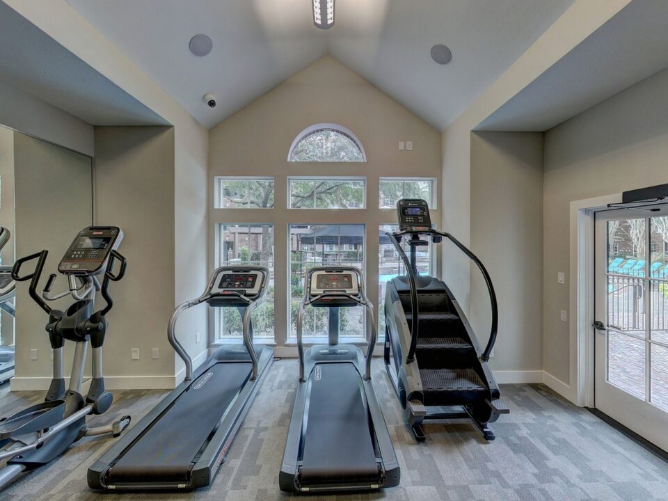 Two treadmills, a stepper, and a cross trainer, all in a home gym setup, vital pieces of equipment to consider for your home gym cost
